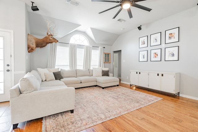 living room with light hardwood / wood-style floors, ceiling fan, and lofted ceiling