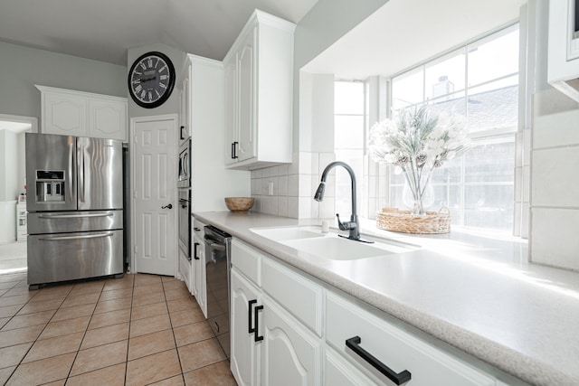 kitchen featuring light tile patterned flooring, sink, white cabinetry, and stainless steel appliances