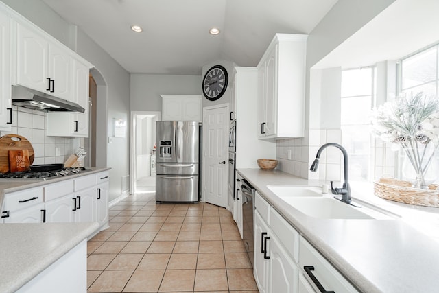 kitchen featuring backsplash, sink, white cabinets, and appliances with stainless steel finishes