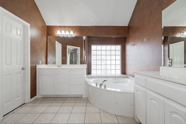 bathroom featuring tile patterned floors, a bathtub, vanity, and lofted ceiling