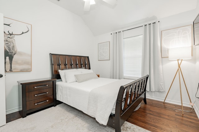 bedroom featuring dark hardwood / wood-style floors, vaulted ceiling, and ceiling fan