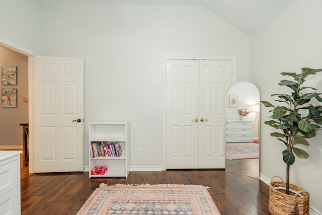 bedroom featuring a closet, dark hardwood / wood-style flooring, and vaulted ceiling