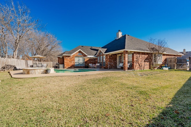 back of house featuring an outdoor kitchen, a yard, and a patio