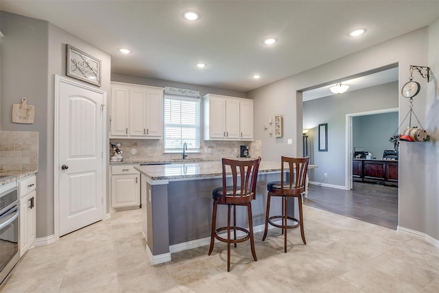 kitchen with white cabinets, a center island, and tasteful backsplash