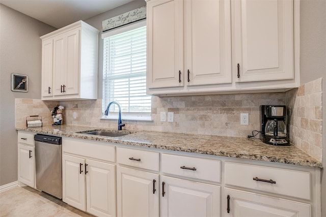 kitchen with white cabinets, tasteful backsplash, stainless steel dishwasher, and sink