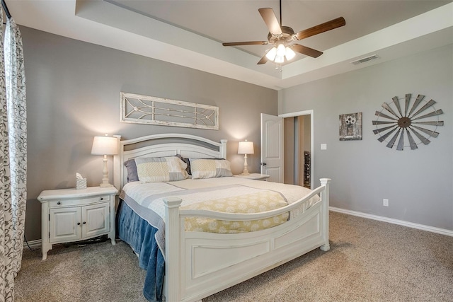 bedroom with carpet floors, a raised ceiling, and ceiling fan