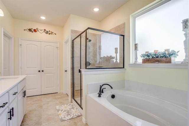 bathroom with tile patterned flooring, vanity, and separate shower and tub