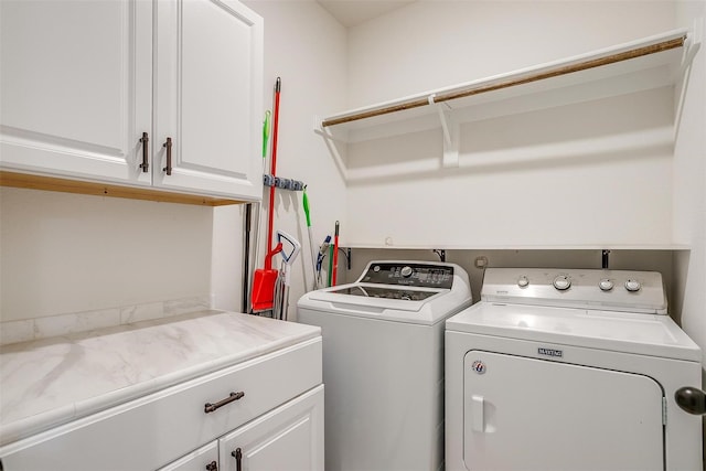 clothes washing area with cabinets and separate washer and dryer