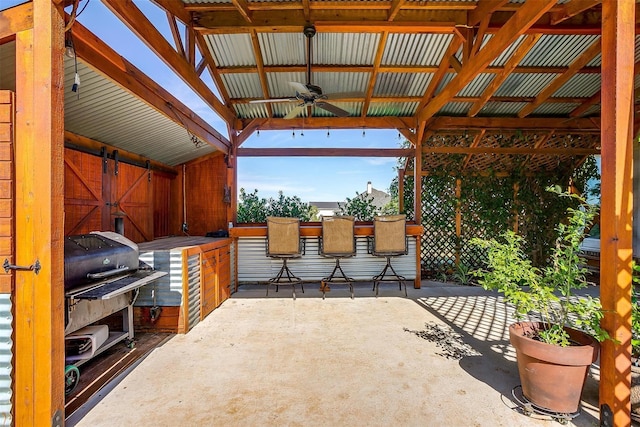 view of patio / terrace with exterior bar, grilling area, and ceiling fan