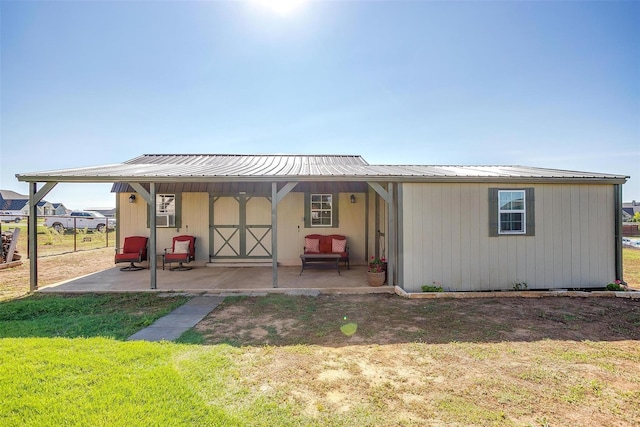 back of property with a yard and an outdoor structure