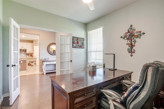 office with ceiling fan, french doors, and light hardwood / wood-style flooring