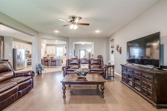 living room with ceiling fan and light wood-type flooring