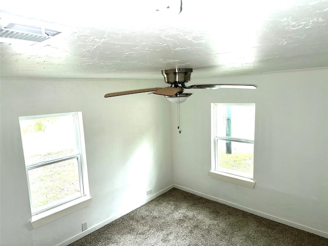 spare room featuring a wealth of natural light, ceiling fan, and carpet floors