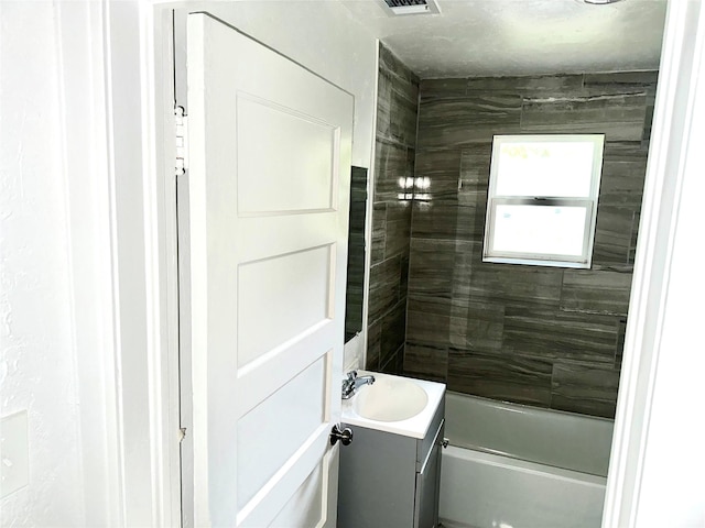 bathroom with vanity and tiled shower / bath combo