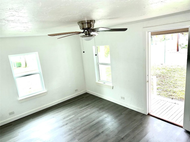 empty room with ceiling fan, a textured ceiling, baseboards, and dark wood-type flooring