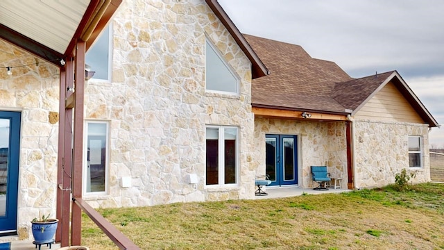 rear view of house featuring french doors, a patio area, and a lawn