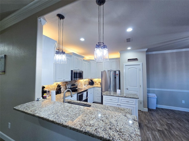 kitchen with kitchen peninsula, white cabinets, hanging light fixtures, and appliances with stainless steel finishes