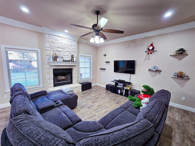 living room with a fireplace, wood-type flooring, ceiling fan, and crown molding