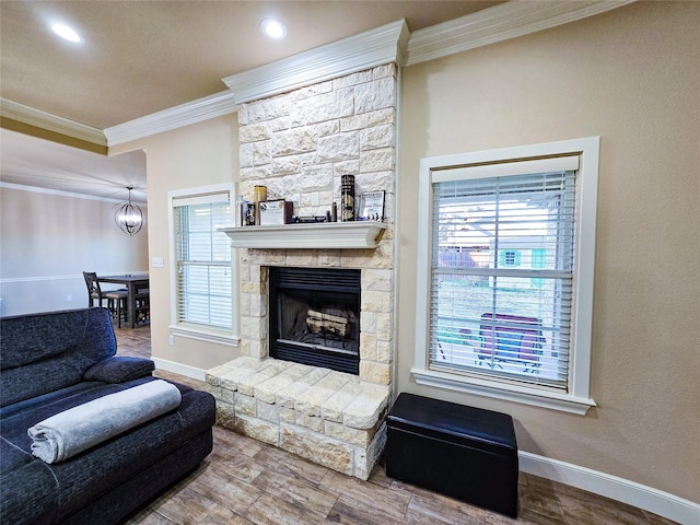 living room featuring hardwood / wood-style flooring, a fireplace, a notable chandelier, and ornamental molding