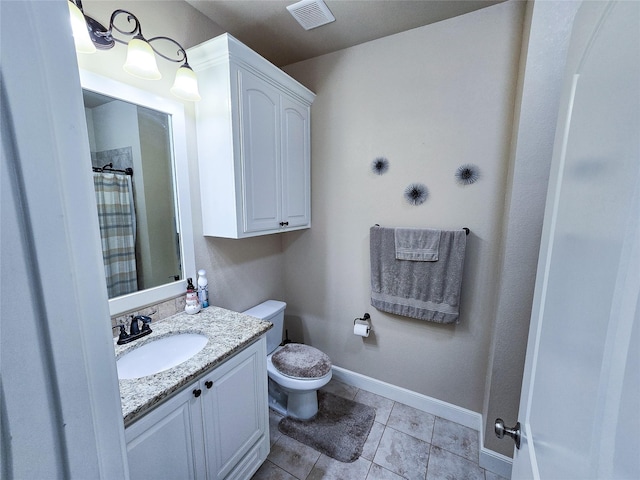 bathroom with tile patterned flooring, vanity, and toilet