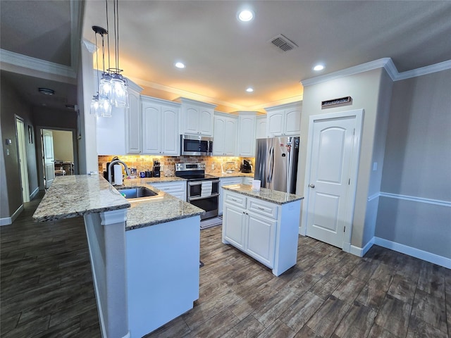 kitchen with light stone countertops, sink, kitchen peninsula, white cabinets, and appliances with stainless steel finishes