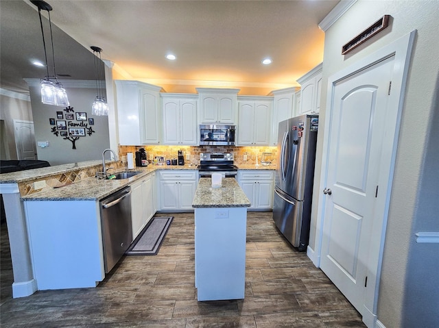 kitchen with white cabinetry, sink, light stone counters, kitchen peninsula, and appliances with stainless steel finishes