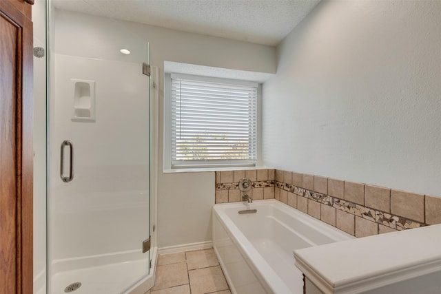 bathroom with tile patterned flooring, a textured ceiling, and separate shower and tub