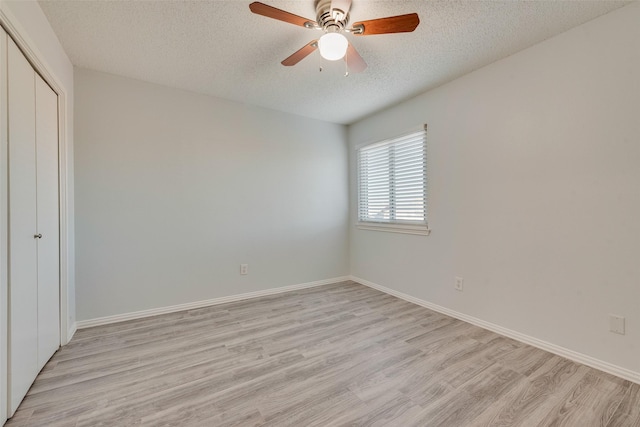 unfurnished bedroom with ceiling fan, light hardwood / wood-style flooring, a textured ceiling, and a closet