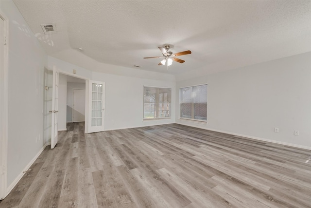 unfurnished room featuring french doors, a textured ceiling, light hardwood / wood-style flooring, and ceiling fan