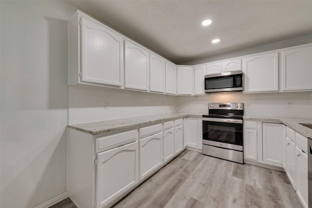 kitchen featuring white cabinetry, a textured ceiling, and appliances with stainless steel finishes