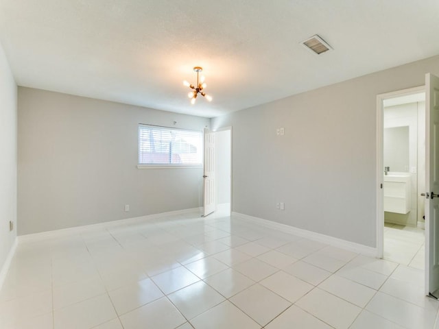 empty room featuring light tile patterned floors and a notable chandelier