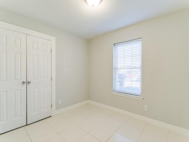 unfurnished bedroom with light tile patterned floors and a closet