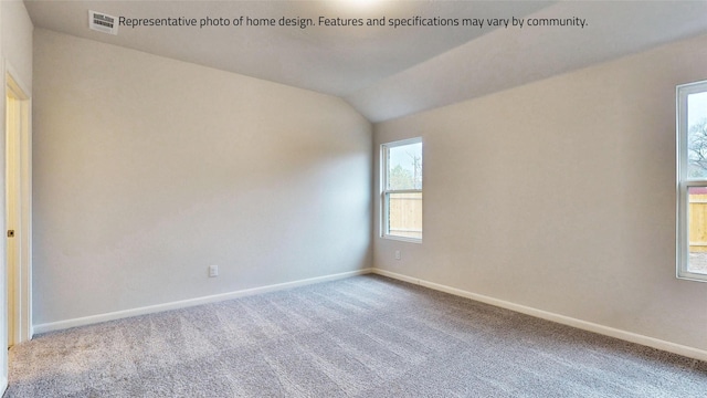 empty room featuring carpet and vaulted ceiling