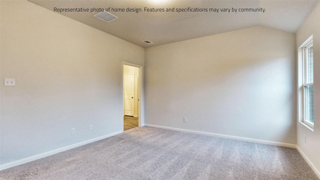 carpeted spare room with vaulted ceiling