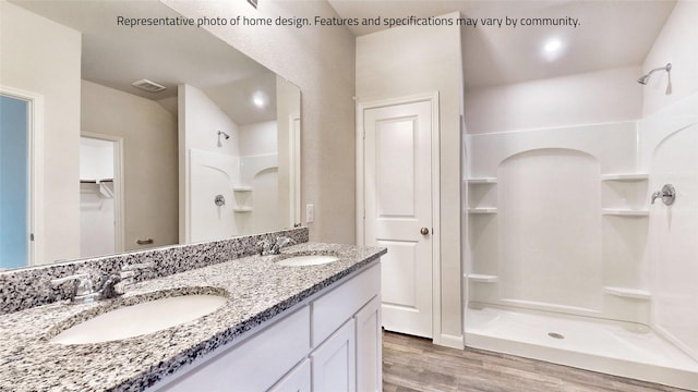 bathroom featuring a shower, hardwood / wood-style floors, and vanity