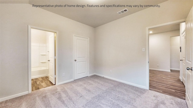 unfurnished bedroom with light colored carpet and ensuite bath