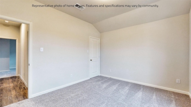 unfurnished room featuring dark colored carpet and vaulted ceiling