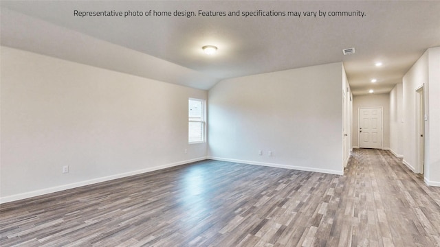 unfurnished room with wood-type flooring and lofted ceiling