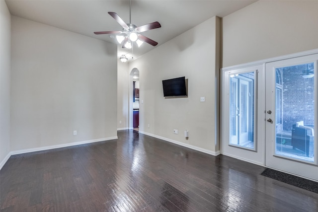 empty room featuring lofted ceiling, dark hardwood / wood-style floors, ceiling fan, and french doors