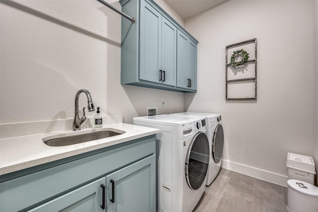 laundry area featuring cabinets, dark tile patterned floors, sink, and washing machine and clothes dryer