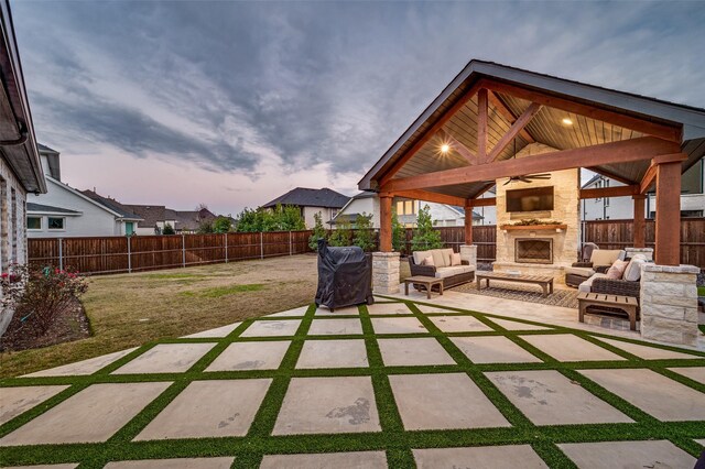 view of patio / terrace featuring an outdoor living space with a fireplace, a gazebo, and ceiling fan