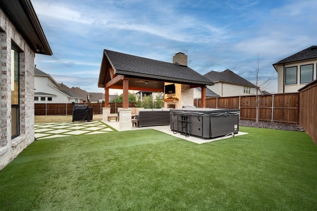 rear view of house featuring outdoor lounge area, ceiling fan, a patio area, a yard, and a hot tub