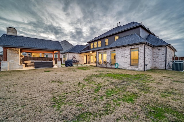 back of property featuring a patio area, an outdoor living space, a yard, and cooling unit