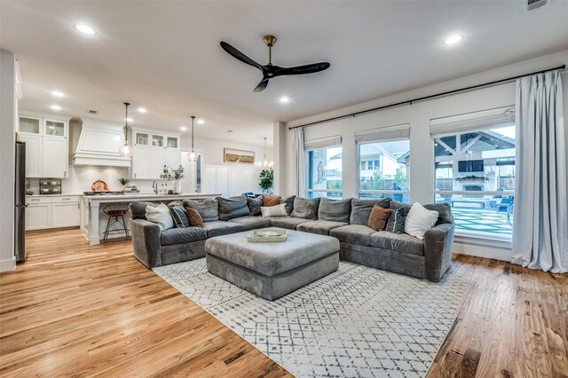 living room with light hardwood / wood-style floors and ceiling fan