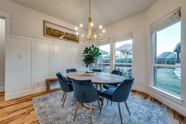 dining area featuring hardwood / wood-style flooring and an inviting chandelier