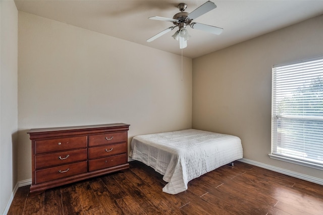 bedroom featuring ceiling fan, dark hardwood / wood-style flooring, and multiple windows