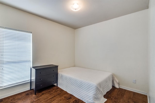 bedroom with dark hardwood / wood-style flooring