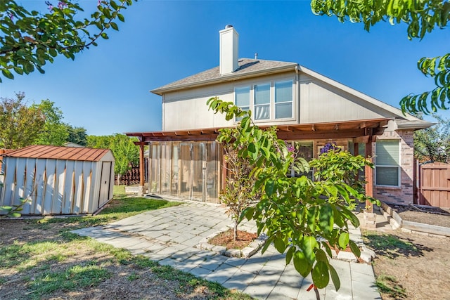 back of property with a patio area and a storage unit