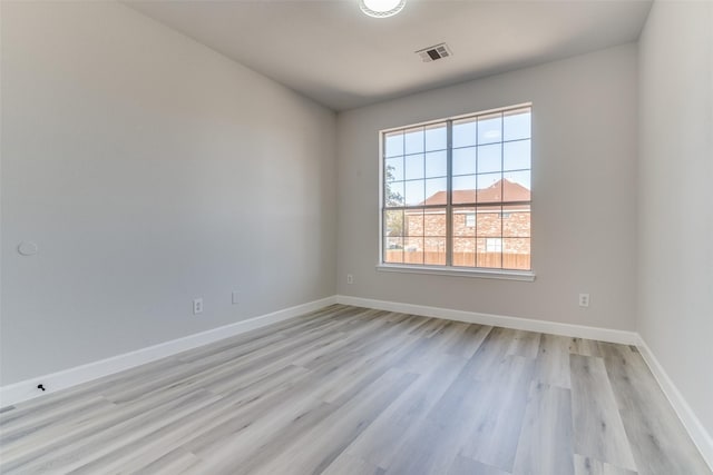 empty room featuring a healthy amount of sunlight and light hardwood / wood-style floors