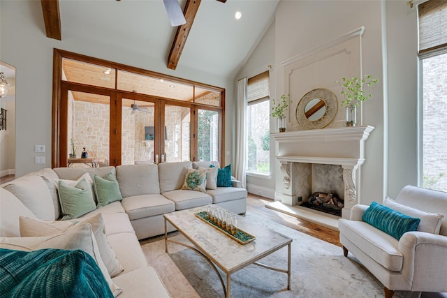 living room featuring french doors, light wood-type flooring, lofted ceiling with beams, and ceiling fan